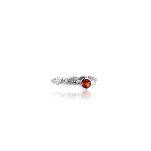 Silver ring with orange garnet on white background