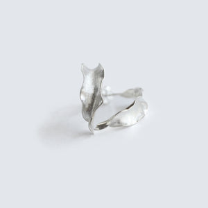 Silver Flame lily petal earrings on soft grey background