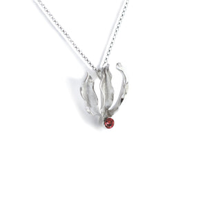 Silver flame lily pendant with red garnet gemstone on chain. White background