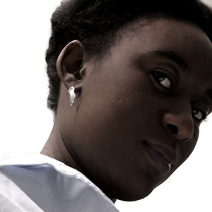 girl wearing small silver flame lily hoop earring