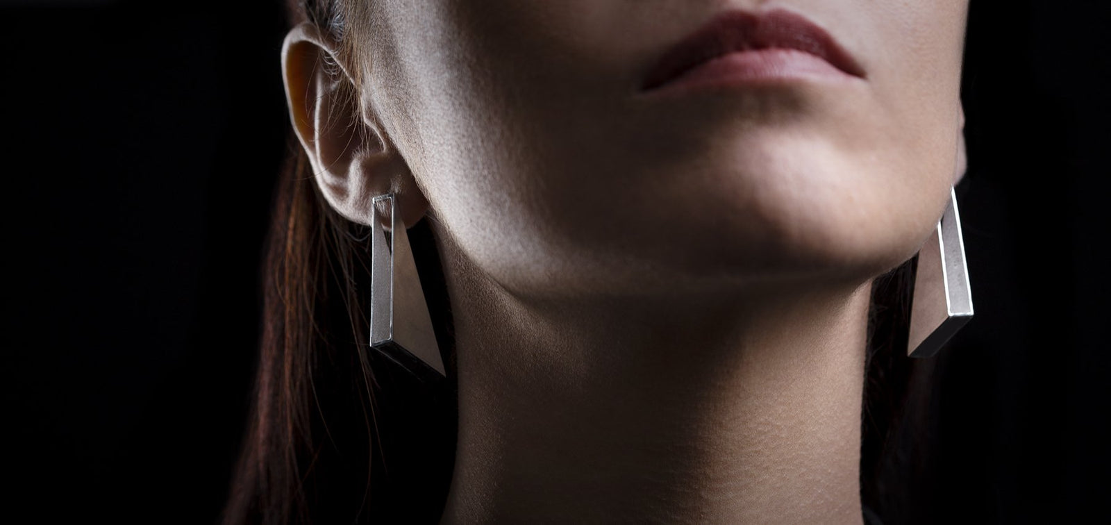 Lady wearing large silver earrings. designer jewellery