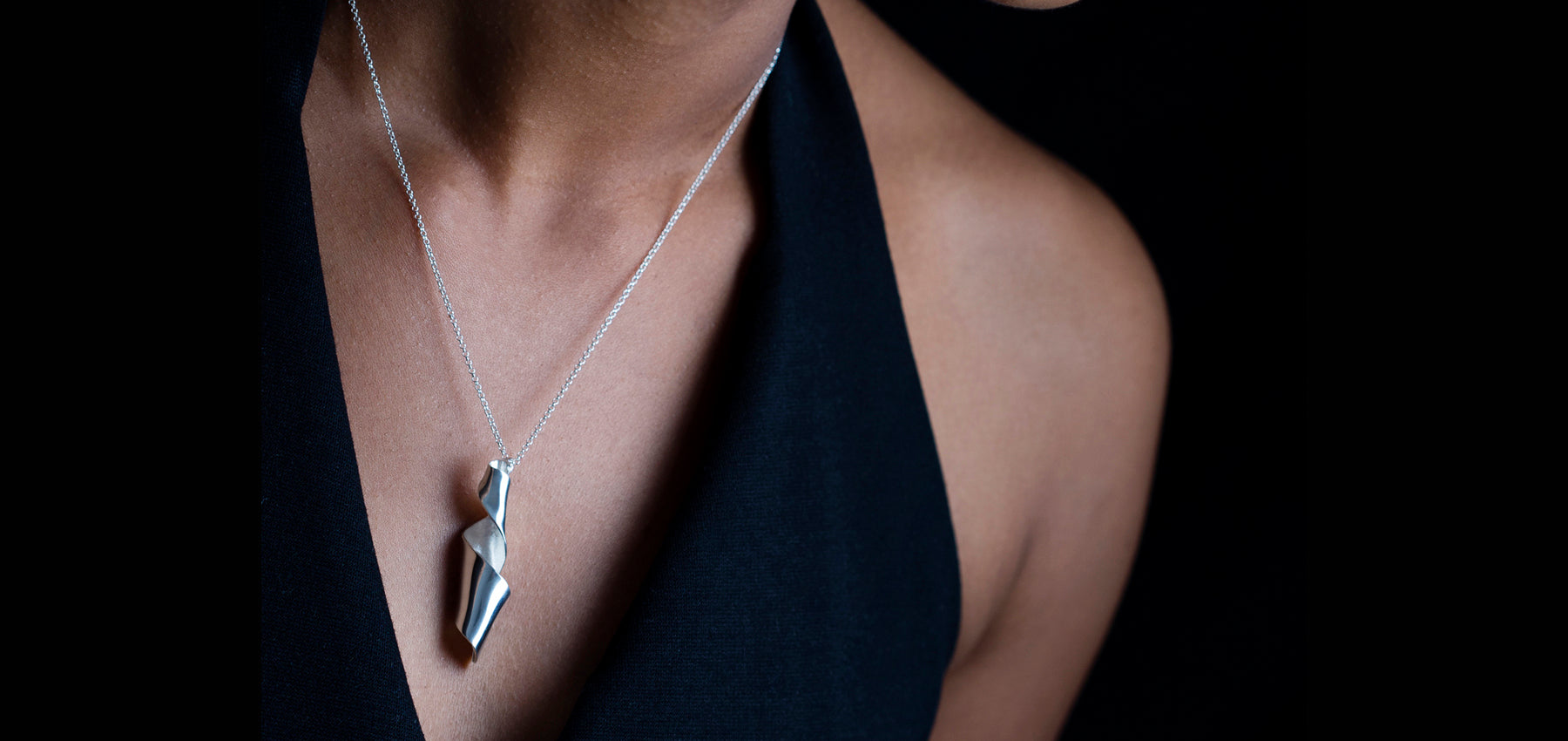 Woman wearing necklace with large silver pendant