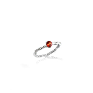 Silver ring with orange garnet on white background