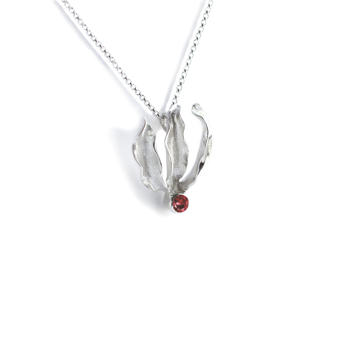 Silver flame lily pendant with red garnet gemstone on chain. White background