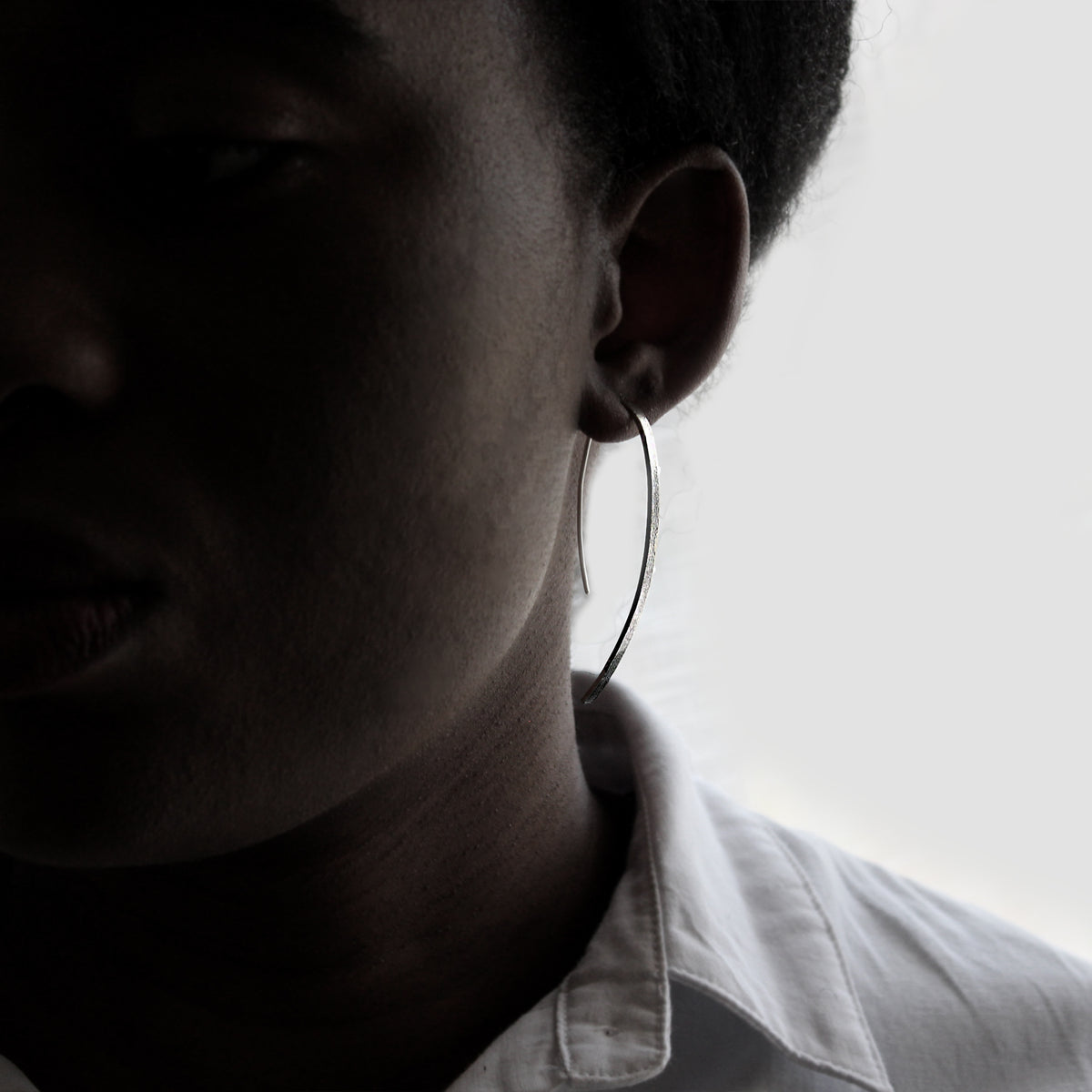 Silver Arch Earrings on model . Head-shot Frontview