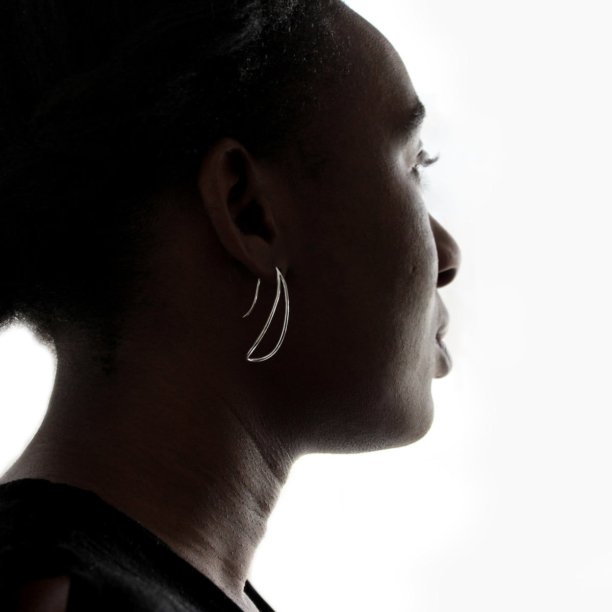Silver loop earring on a model. White Background