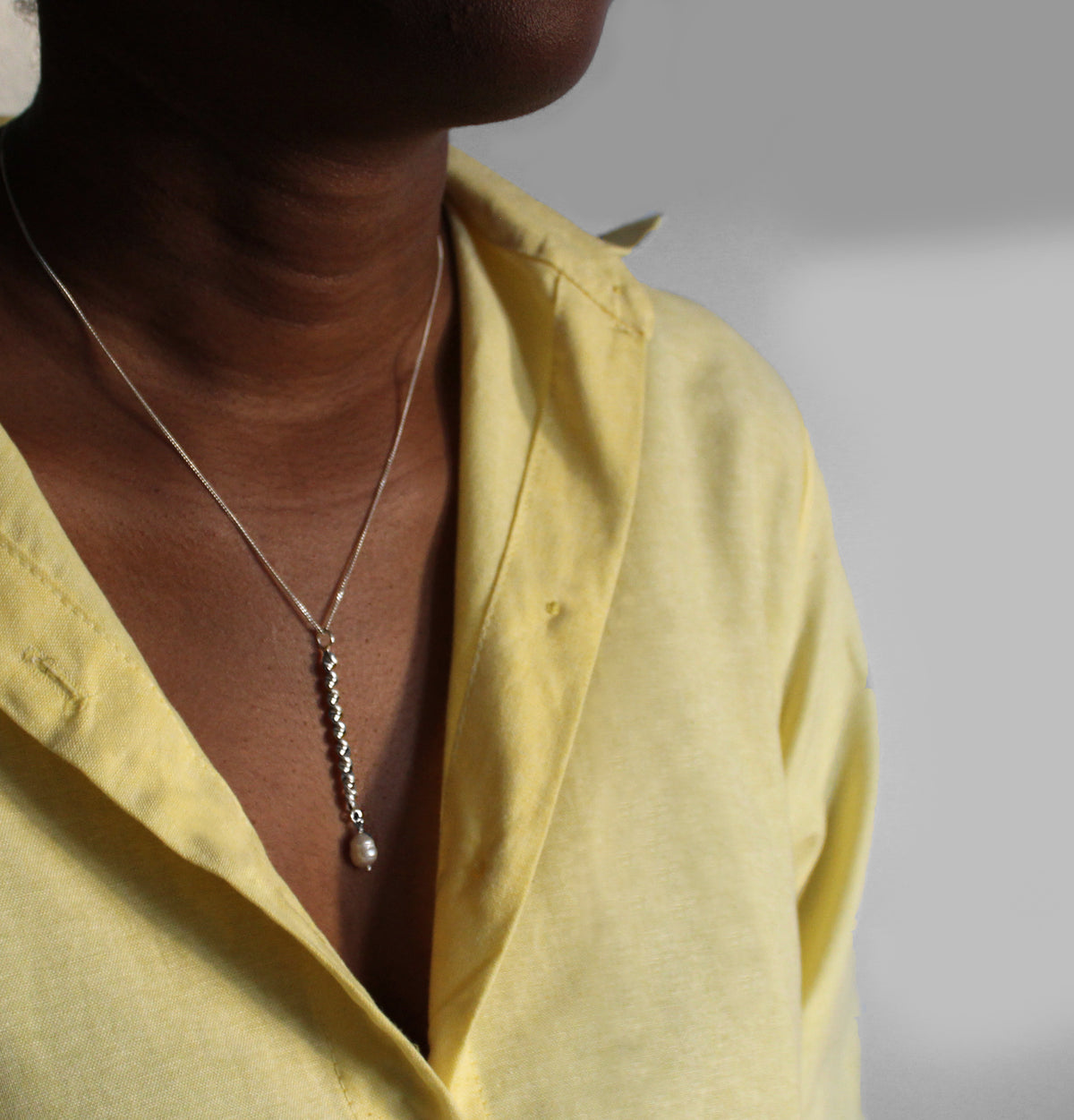 Silver twisted chain with ringed pearl on model