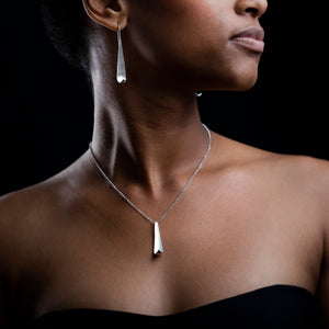 Model wearing Poised Chain and poised studs. Black background
