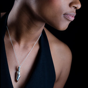 Large Msasa Pod chain hanging on a woman's neck. Black background.