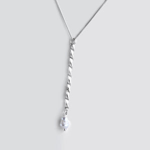 Silver twisted chain with pearl on grey background