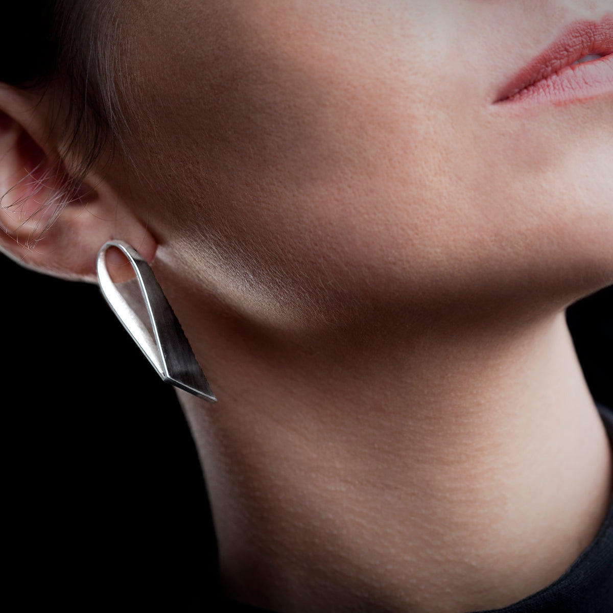 Long silver stud on model black background. 