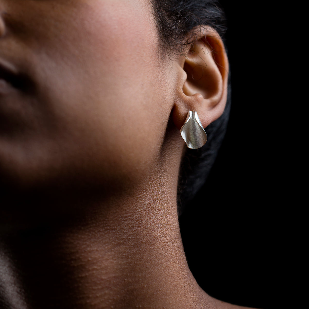 Silver Pod studs on a model. black background