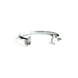 Silver bangle with two butterflies on white background.