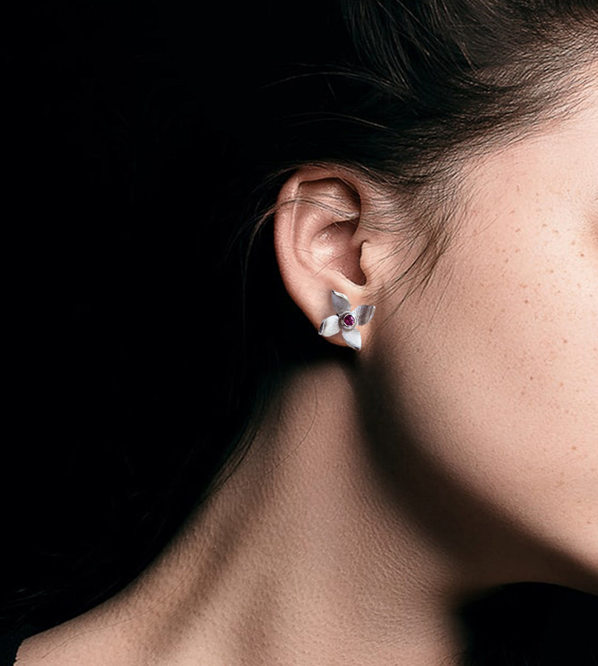 Flower studs on a woman black background 