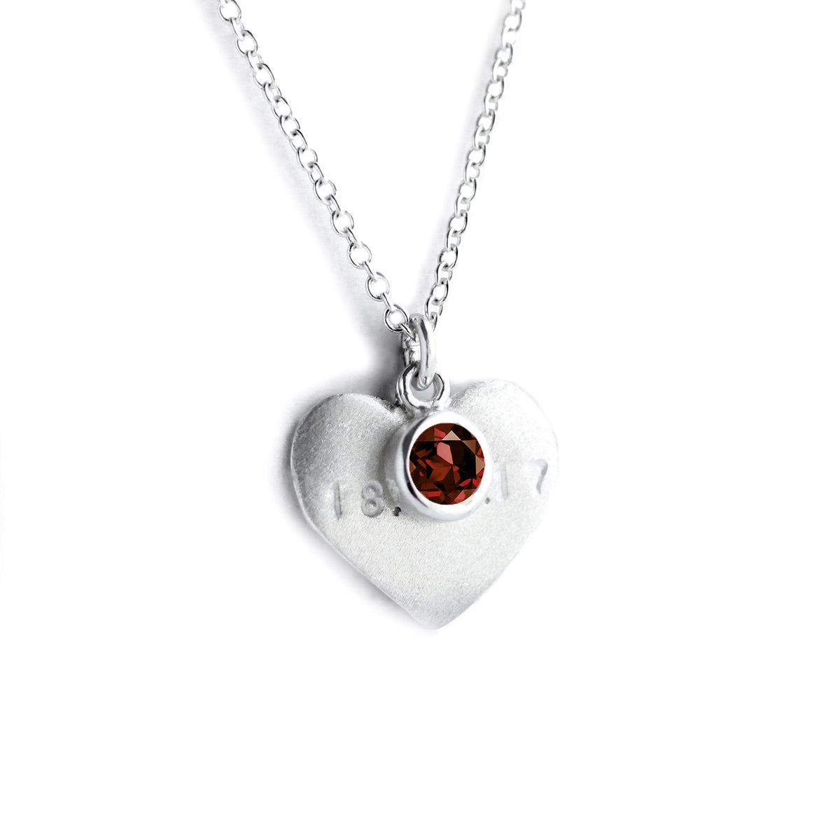 Silver heart on chain with engraved date and red garnet on top
