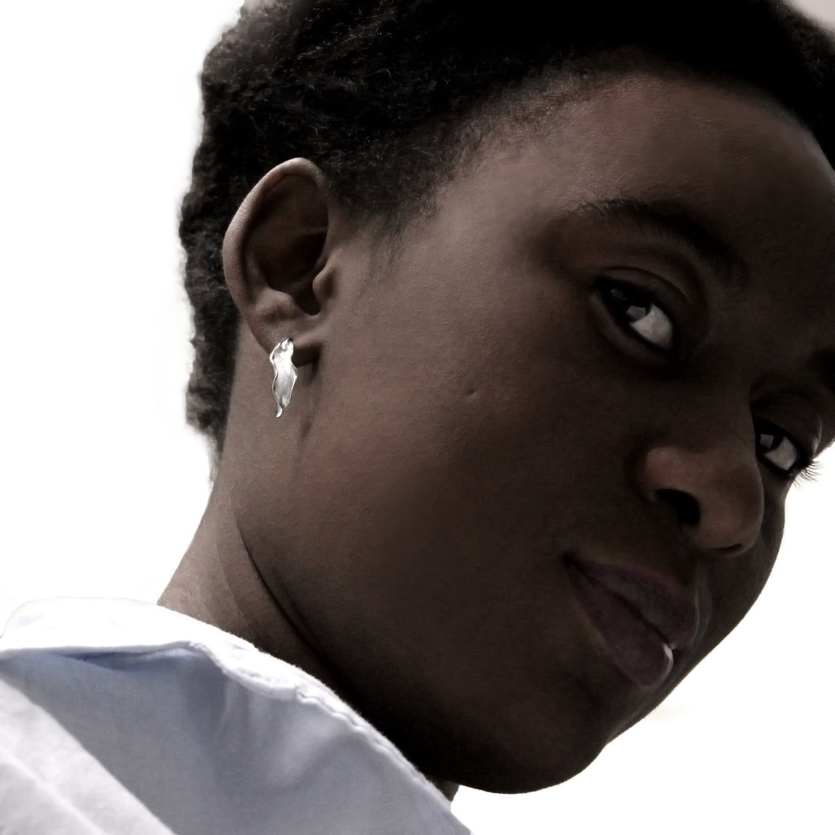 girl wearing small silver flame lily hoop earring